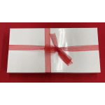 Rectangular white gift box with a sheer red ribbon and bow on a red background