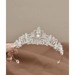A jeweled silver tiara is held in a hand against a plain background.