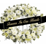 White floral wreath on an easel with a memorial ribbon