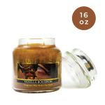 Vanilla bourbon candle in a glass jar with a lid beside it