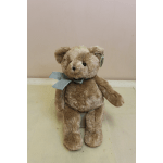 Plush teddy bear with a ribbon bow around its neck