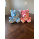Blue and pink teddy bears sitting on a table