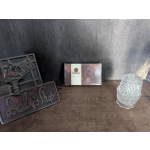 Decorative tabletop signs and a glass candle holder on a wooden surface