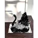 Black floral arrangement with a swan figurine in a mirrored tray
