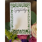 Sympathy card with green glitter border in a floral arrangement