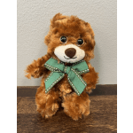 Brown teddy bear with a green ribbon bow