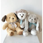 Three plush stuffed dogs with ribbon bows sitting together