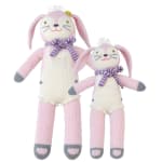 Two knitted bunny plush toys in pink and white with purple scarves