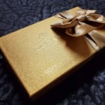 Gold gift box with a satin ribbon bow