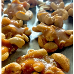 Caramel-coated nut clusters on a baking tray