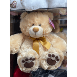 Plush teddy bear with a gold ribbon and paw-print feet