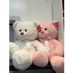 Two plush teddy bears, one white and one pink, with ribbon bows
