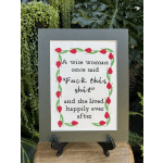 Framed cross-stitch quote with red tulips on a green border
