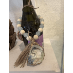 Decorated prosecco bottle with a beaded garland and hanging shell ornament