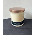 A mango and coconut milk candle in a glass jar with a metallic lid
