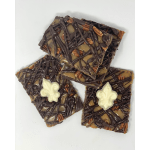 Chocolate-drizzled candy bark pieces with pecans and white decorations