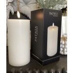White flameless pillar candle beside its black retail box