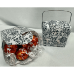 Two decorative gift boxes, one filled with wrapped chocolates