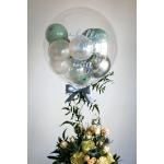 Clear balloon with green balloons and "hello baby boy" text above a floral arrangement
