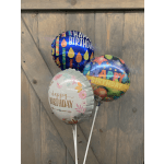 Three birthday balloons with colorful printed designs and white sticks