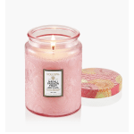 Pink scented candle in a glass jar with a patterned lid