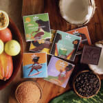 Assorted chocolate bars and tropical fruits arranged on a wooden surface.