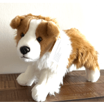 Plush brown-and-white dog standing on a wooden surface