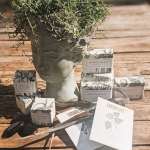 Potted greenery in a sculpted stone head planter with boxed soaps around it