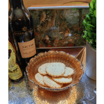 A bowl of cookies sits beside wine bottles and a decorative box.