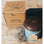 A blue candle tin with a wooden lid beside a kraft box