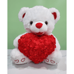 White teddy bear holding a red heart