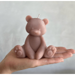 Pink bear-shaped candle sitting in a hand