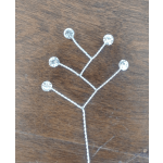 Silver decorative hair accessory with clear rhinestones on a wooden surface