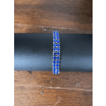 Blue rhinestone bracelet on a black display stand