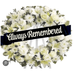White floral wreath on an easel with an "Always Remembered" ribbon