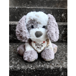 Plush dog holding a heart that says "HUG ME"