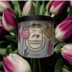 Candle jar labeled Cranberry Mandarin surrounded by pink tulips