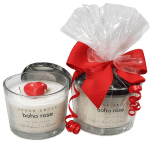 Two scented candles in glass jars, one with a heart-shaped wax topper and one gift-wrapped with a red ribbon.