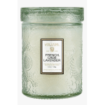 Green glass candle jar with a lid and label reading French Cade Lavender