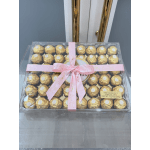 Box of gold-wrapped chocolates tied with a pink ribbon