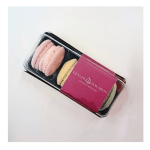 Box of pastel macarons with a pink sleeve