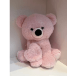 Pink teddy bear plush toy sitting in a box