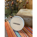 Lavender soy wax candle in a round tin beside a rustic box