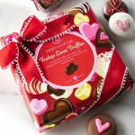 Box of heart-shaped chocolate truffles with red ribbon wrapping