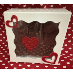 White gift box with red glitter hearts on a heart-patterned red background