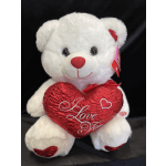 White teddy bear holding a red heart pillow