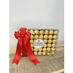 Box of Ferrero Rocher chocolates tied with a red ribbon