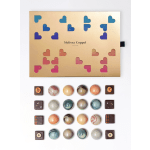 Box of assorted chocolates with a gold lid and colorful heart cutouts