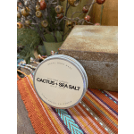 Soy wax candle tin labeled Cactus + Sea Salt on a woven table runner