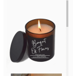 Lit amber jar candle with a black lid labeled Bouquet Of Flowers